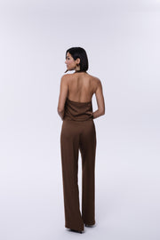 Woman wearing a brown jumpsuit on a white background